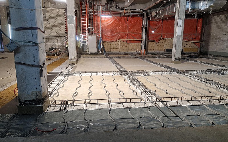 Verlegung von Kühl- und Heizleitungen im Bodenaufbau einer Industriehalle mit vorbereiteter Bewehrung